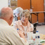 A woman looks at a man seated next to her at a table